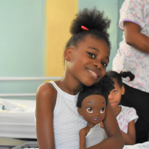 Petite fille Haïtienne sur un lit à l'hôpital Saint-Damien. 