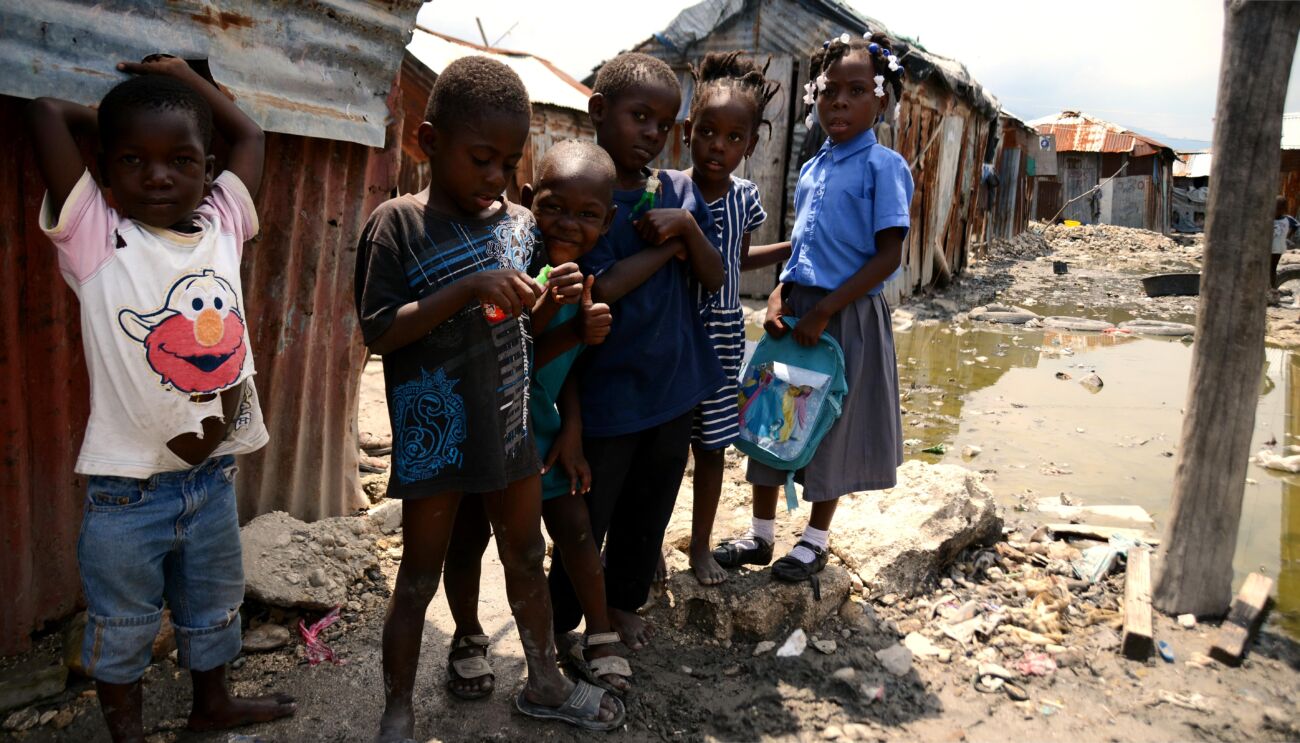 Des enfants sont pris en photo dans les rues insalubres en Haïti qui montrent l'état de la pauvreté du pays.